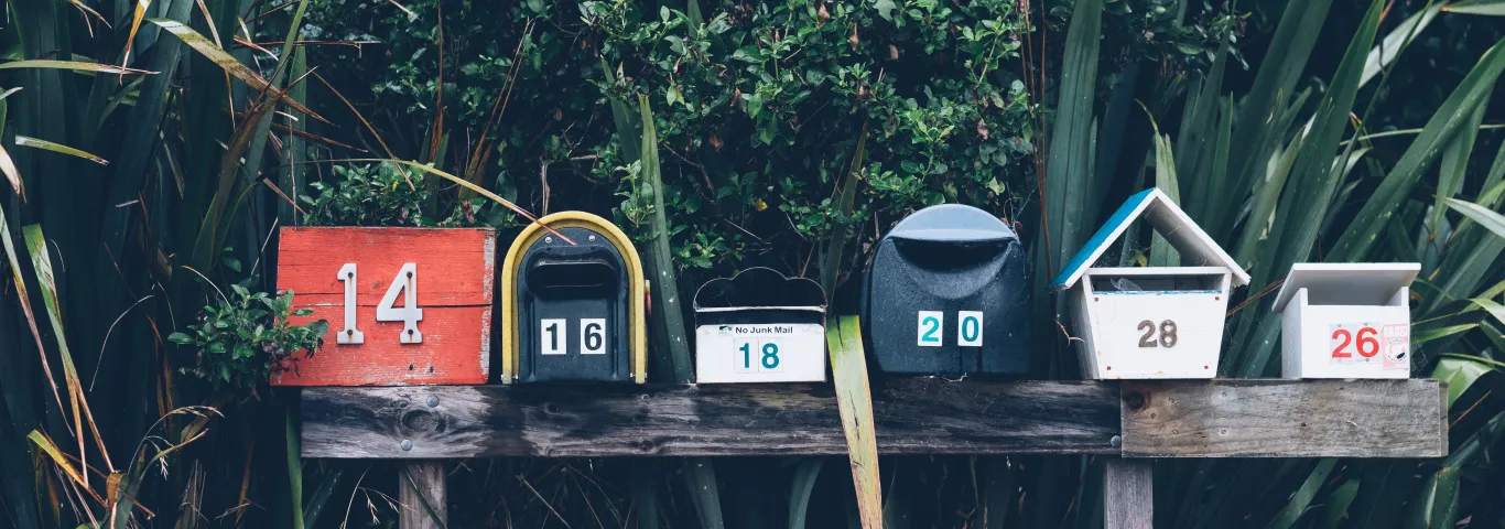 a row of six multicolored mailboxes