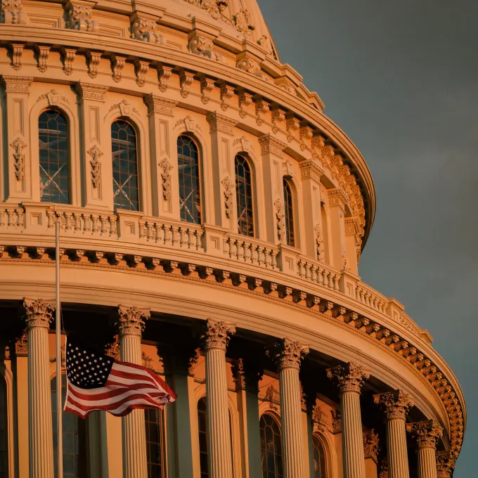 closeup of flag in front of US Capital building